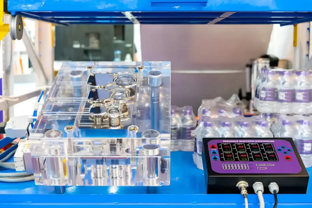 An acrylic plastic mold is shown next to a sequence injection controller box. 