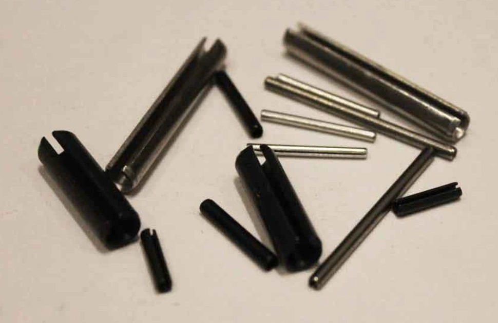 A collection of hollow, slotted pins in varying sizes, with a mix of black and silvery finishes