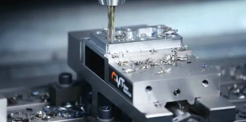 CNC machine milling a detailed metal component.