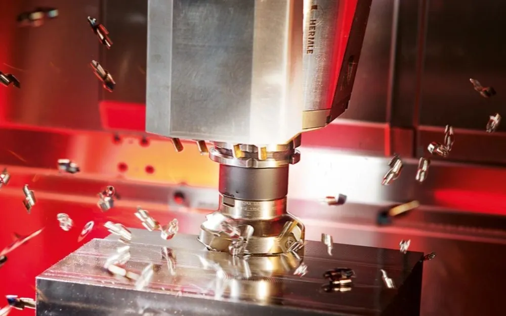 Chips flying as a CNC milling machine cuts a titanium component