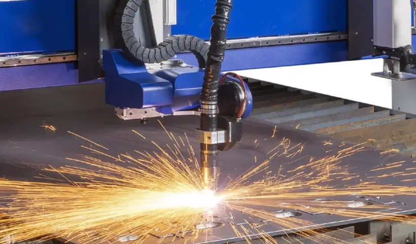 A CNC plasma cutter cutting a thick sheet of metal with sparks showing