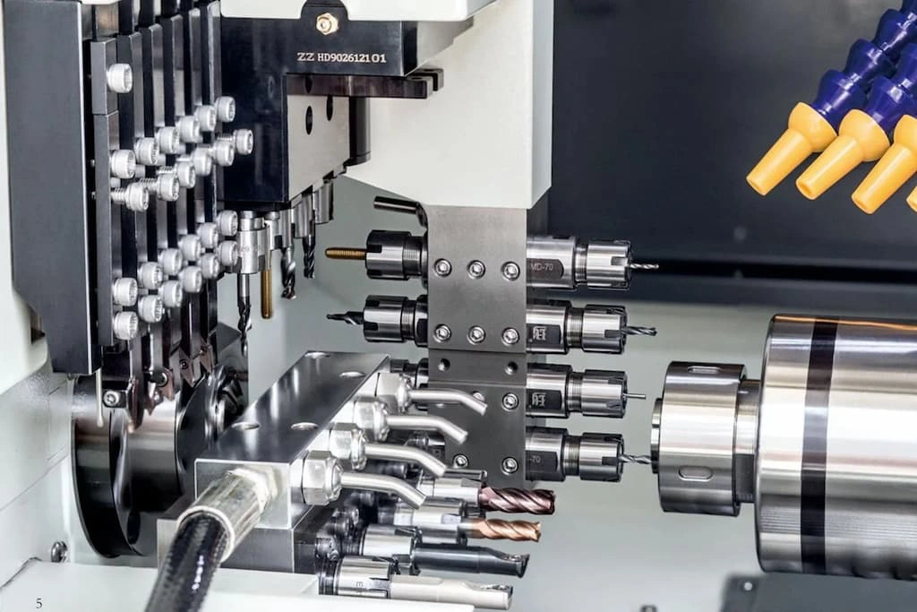 A close-up view of Swiss-type lathe machining, various tools are attached to the ATC mechanism 