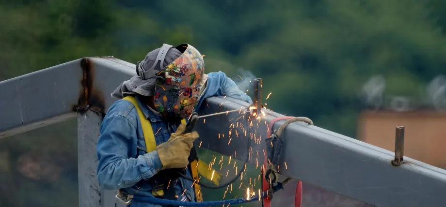 Man holding a Tig torch welding a metal girder