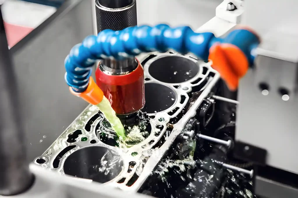 Coolant flowing over the CNC tool and automotive engine part during machining.