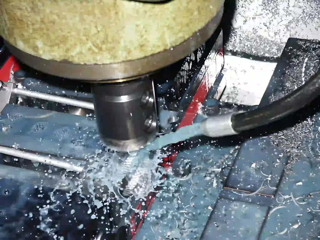 The image shows coolant fluid flowing over a cutting tool during a CNC machining process.