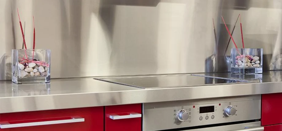 Stainless steel laser-cut kitchen backsplash and countertop with an over-door and glass decorations.