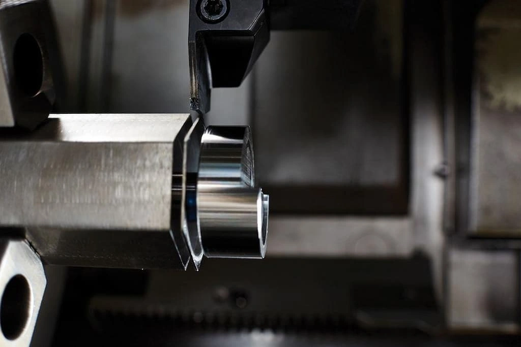 A close-up view of the parting operation, the finished section is about to be separated from long bar 