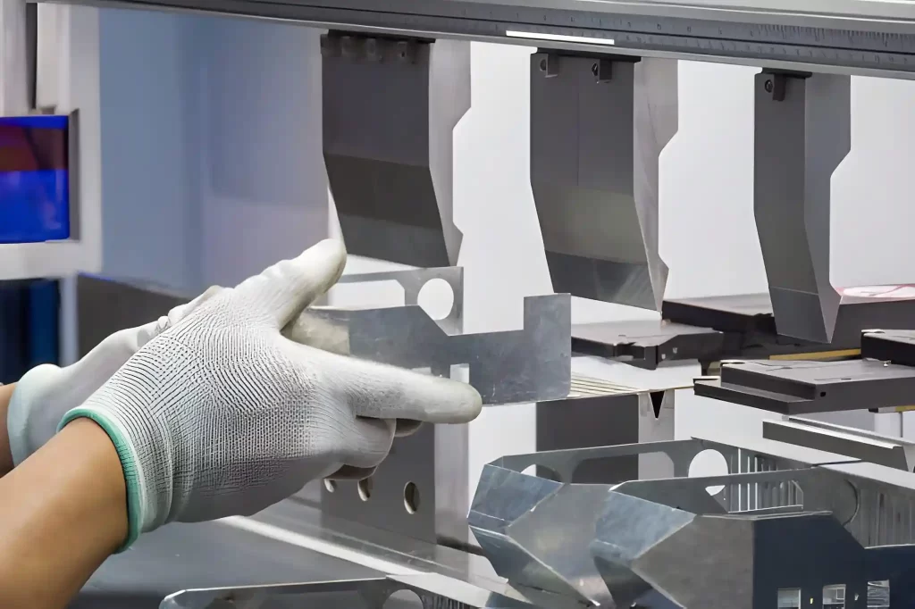 An operator bending sheet metal parts into specified shapes using a press brake.