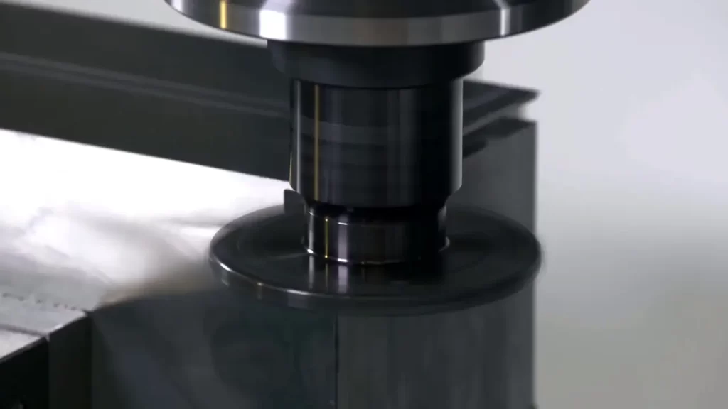 Close-up of a square shoulder milling cutter machining a metal workpiece, showing the cutting tool creating precise flat surfaces and sharp corners.