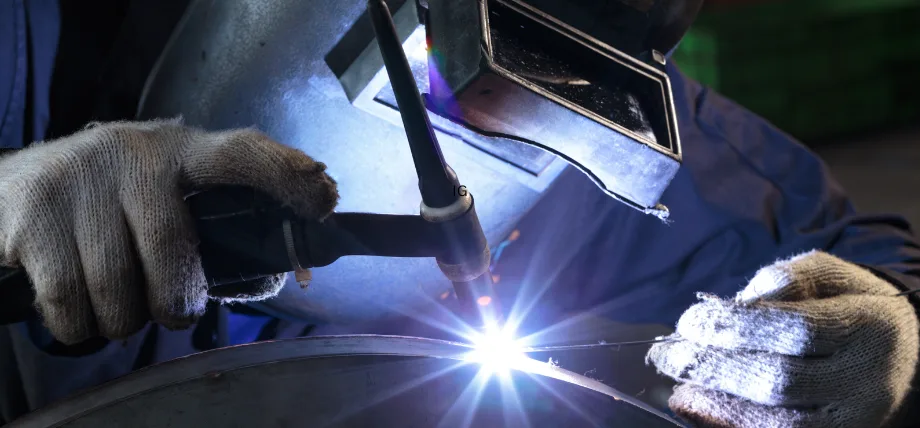 Person holding a welding torch and electrode for tig welding with a spark 