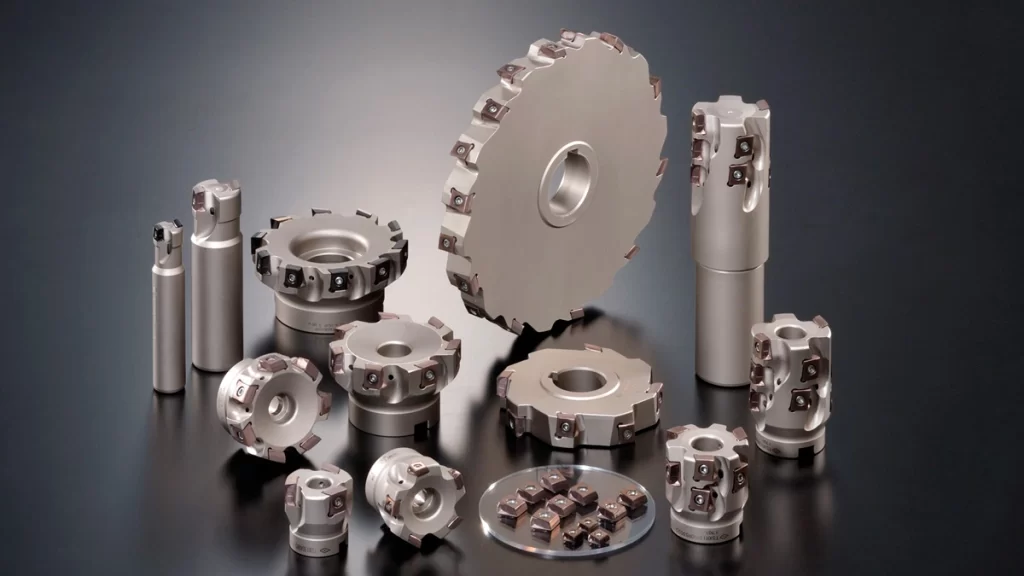 Different types of shoulder mill cutters, including face mills, end mills, disc cutters, and indexable inserts, arranged on a dark background for precision machining applications.