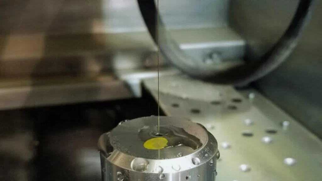 An image depicting a Wire EDM process where a steel part is precisely cut through its center