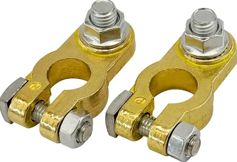 Two yellow brass car battery terminals, each equipped with a matching silvery bolt and screw assembly for clamping 