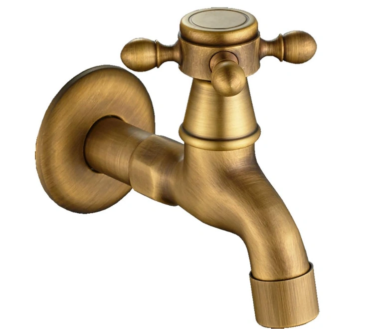 An image of a traditional yellow wall-mounted water tap made of yellow brass